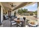 Inviting covered patio with comfortable seating, a ceiling fan, and a view of the landscaped backyard at 15434 W Big Sky Dr, Surprise, AZ 85374