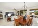Bright dining area features a wooden table and six chairs set adjacent to a living room with large windows at 15434 W Big Sky Dr, Surprise, AZ 85374