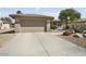 Single-story home with a desert landscaped front yard, and an attached two car garage with a long driveway at 15434 W Big Sky Dr, Surprise, AZ 85374