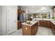 Open kitchen with stainless steel appliances, center island, wood cabinets, and an open layout to the dining and living areas at 15434 W Big Sky Dr, Surprise, AZ 85374