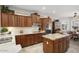Updated kitchen featuring tile backsplash, wood cabinets, stainless steel appliances, and central island with granite top at 15434 W Big Sky Dr, Surprise, AZ 85374