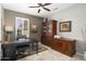 Office featuring a ceiling fan, window, dark walls, built-in shelving, and tile floors at 15434 W Big Sky Dr, Surprise, AZ 85374