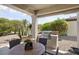 An outdoor kitchen and dining area with a built-in grill and a desert-landscaped backyard at 15434 W Big Sky Dr, Surprise, AZ 85374