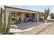 Charming covered patio with ample seating, ceiling fans, and a beautiful desert landscape at 15434 W Big Sky Dr, Surprise, AZ 85374