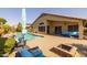 Sparkling backyard pool with patio furniture, lounge seating, lush landscaping, and a built-in firepit at 16577 W Garfield St, Goodyear, AZ 85338