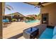 Backyard patio with view of sparkling pool, lounge furniture, and mature landscaping at 16577 W Garfield St, Goodyear, AZ 85338