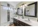 Bathroom featuring double sinks, walk-in shower with tile surround, and great natural lighting at 16577 W Garfield St, Goodyear, AZ 85338