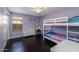 bedroom featuring purple walls, wood floors, white bunk beds and a desk by the window at 16577 W Garfield St, Goodyear, AZ 85338