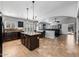 Expansive kitchen with an island, dark cabinets, and seamless flow into the cozy living area at 16577 W Garfield St, Goodyear, AZ 85338