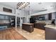 This kitchen features an island, brown cabinets, tile floor, tile backsplash, and stainless steel appliances at 16577 W Garfield St, Goodyear, AZ 85338