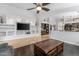 Bright living room featuring a built-in shelving, dark floors, and an opening to the kitchen area at 16577 W Garfield St, Goodyear, AZ 85338