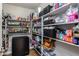Walk-in pantry with lots of shelving space holding food and house hold items at 16577 W Garfield St, Goodyear, AZ 85338