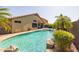 View of the backyard pool with rock waterfall, landscaping, and exterior of the home at 16577 W Garfield St, Goodyear, AZ 85338