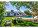 Inviting backyard oasis with a sparkling pool, lush lawn, and cozy seating area for outdoor relaxation at 1708 E Impala Ave, Mesa, AZ 85204