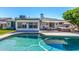 Backyard with a pool, patio furniture, and lush green landscaping at 1708 E Impala Ave, Mesa, AZ 85204