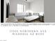 Bright bedroom with a black bed frame, and a large window at 17205 W Northern Ave, Waddell, AZ 85355