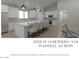 Modern kitchen with a large island, stainless steel appliances, pendant lighting, and white cabinetry at 17205 W Northern Ave, Waddell, AZ 85355