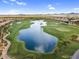 Picturesque aerial view showcases a lush golf course and a peaceful lake with surrounding landscape at 175 E Santa Lucia Ln, Queen Creek, AZ 85140