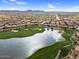 Expansive aerial view showcases a golf course, lake, and residential area with mountain views in the distance at 175 E Santa Lucia Ln, Queen Creek, AZ 85140