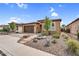 Inviting single-story home featuring a two-car garage, desert landscaping, and a stone pathway at 175 E Santa Lucia Ln, Queen Creek, AZ 85140