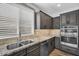 Kitchen with stainless steel sink, modern appliances, granite counters, and dark wood cabinetry at 175 E Santa Lucia Ln, Queen Creek, AZ 85140