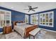 Comfortable main bedroom with blue walls, shuttered windows, ceiling fan, and neutral-toned decor at 175 E Santa Lucia Ln, Queen Creek, AZ 85140