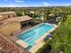 Aerial view of a well-maintained community pool with a lap lane and a relaxing lounge area under shady palm trees at 175 E Santa Lucia Ln, Queen Creek, AZ 85140