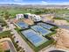 Aerial view featuring multiple community tennis courts, landscaped grounds, and residential buildings in the background at 175 E Santa Lucia Ln, Queen Creek, AZ 85140