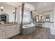 Luxurious bathroom featuring a soaking tub, elegant lighting, double vanities, and a serene atmosphere at 18438 N 96Th Way, Scottsdale, AZ 85255