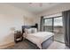 Comfortable bedroom with sliding glass door leading to a balcony, and a neutral color palette at 18438 N 96Th Way, Scottsdale, AZ 85255