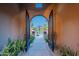 Grand entrance with iron gates opening to a serene view of a pool and desert landscape at 18438 N 96Th Way, Scottsdale, AZ 85255