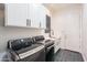 Laundry room features modern washer and dryer, white cabinets and sink at 18438 N 96Th Way, Scottsdale, AZ 85255