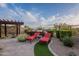 Inviting patio with comfortable seating, lush greenery, and a pergola for shade at 18438 N 96Th Way, Scottsdale, AZ 85255