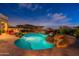 Beautiful backyard with a custom pool, stone accents, spa, and covered seating area, great for entertaining at 18438 N 96Th Way, Scottsdale, AZ 85255