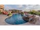 Beautiful swimming pool with rock waterfall feature, seamlessly blending into the desert landscape for ultimate relaxation and enjoyment at 18438 N 96Th Way, Scottsdale, AZ 85255