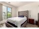 Bedroom with upholstered headboard, bedside table, and sliding glass door to a balcony at 1851 E Frye Rd # 101, Gilbert, AZ 85295