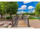 Picturesque view of a community gazebo, accessible via a bridge over a pond with clear blue sky at 1851 E Frye Rd # 101, Gilbert, AZ 85295