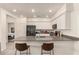 A modern kitchen features white cabinets, a dark gray countertop, and barstool seating at 1851 E Frye Rd # 101, Gilbert, AZ 85295