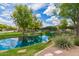 Charming pond scenery, including trees, rocks and landscaping, enhancing the beauty of the surrounding homes at 1851 E Frye Rd # 101, Gilbert, AZ 85295