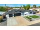 A well manicured lawn and paved driveway lead to this home with a black two-car garage at 1868 E La Donna Dr, Tempe, AZ 85283