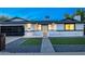 Charming single-story home featuring a modern black garage door, a brick path, and manicured front lawn at 1868 E La Donna Dr, Tempe, AZ 85283