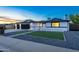 Charming home exterior featuring a black garage door, brick accents, and manicured front yard at dusk at 1868 E La Donna Dr, Tempe, AZ 85283