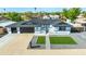 A well manicured lawn and paved walkway lead to this home with a black two-car garage at 1868 E La Donna Dr, Tempe, AZ 85283