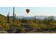 Beautiful desert landscape featuring saguaro cacti and distant mountain ranges with a hot air balloon at 1945 W Desert Vista Trl # 77, Phoenix, AZ 85085