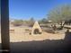 This backyard offers a brick patio, an outdoor fireplace, mature trees and desert landscaping at 20042 W Colter St, Litchfield Park, AZ 85340