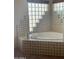 Oversized bathtub featuring tile surround with glass block windows for natural light at 20042 W Colter St, Litchfield Park, AZ 85340