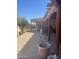 This covered patio features brick flooring, wooden beams, a fireplace, and views of the landscaped yard at 20042 W Colter St, Litchfield Park, AZ 85340