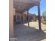 Covered patio boasts exposed wood beams, brick flooring, multiple entry points, and space for outdoor dining at 20042 W Colter St, Litchfield Park, AZ 85340