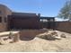 A uniquely designed, unfinished backyard pool with a stone-laid patio, under a rustic wooden pergola at 20042 W Colter St, Litchfield Park, AZ 85340