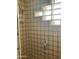 Shower featuring glass block window, beige tiling, and chrome shower head at 20042 W Colter St, Litchfield Park, AZ 85340